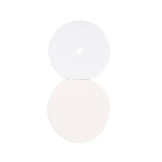 Two white circular objects on a light beige background. Interior shot of the bagel notepad showing blank pages.