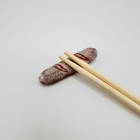 Baguette Chopstick Holder with a pair of chopsticks resting on it.