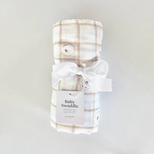 Plaid baby swaddle with a white bow on a light gray background