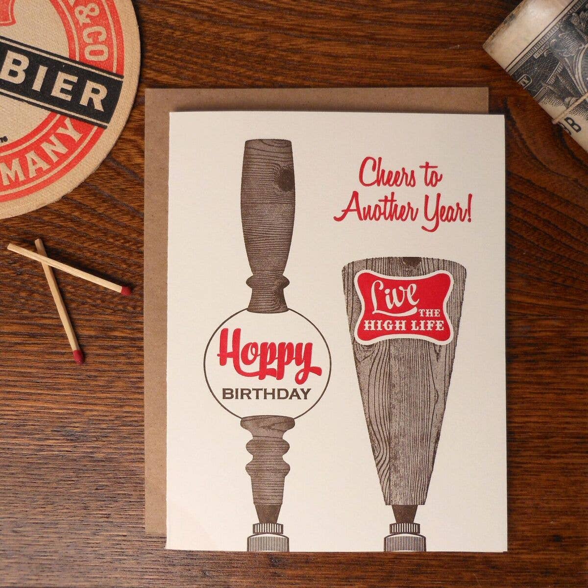 Birthday card with beer-themed tap handle design on a wooden surface