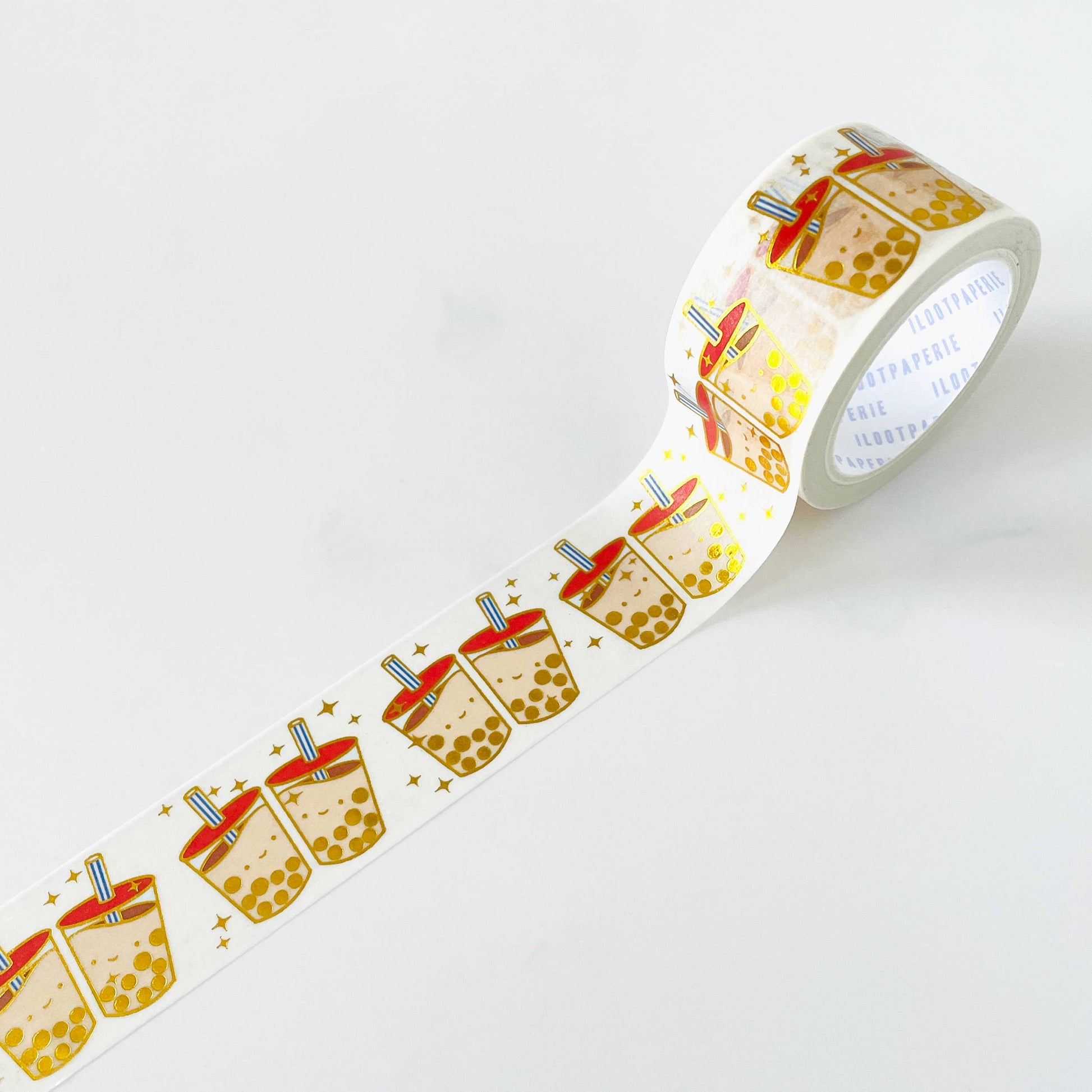 Washi tape with a pattern of 2 boba drinks smiling at eachother. Boba is gold foiled with stars circling the boba cups.