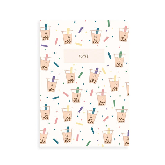 A vertical notebook or notepad with a white cover decorated with a repeating pattern of cute boba tea cups, colorful confetti, and a central label reading 'notes'.