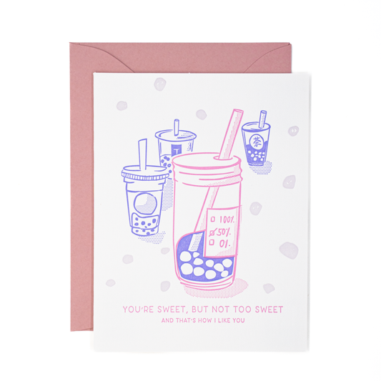 Greeting card with print illustration of four different cups of boba drink with the one in front labeled "50% sweet." Pink, blue and white color palette. Text reads "You're sweet, but not too sweet... and that's how I like you." 