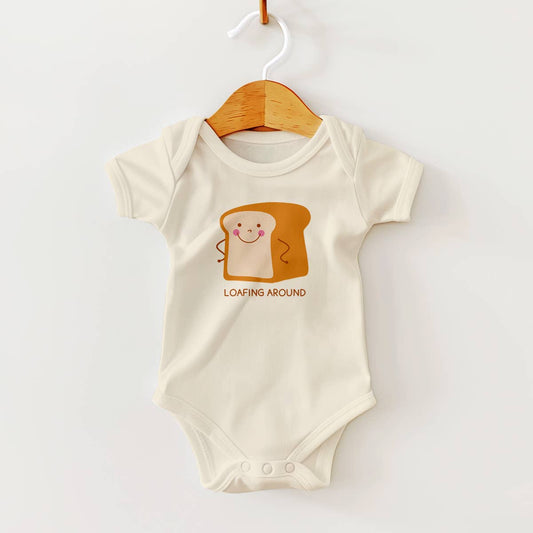 baby onesie with smiley faced loaf of bread on it and text that says "loafing around"