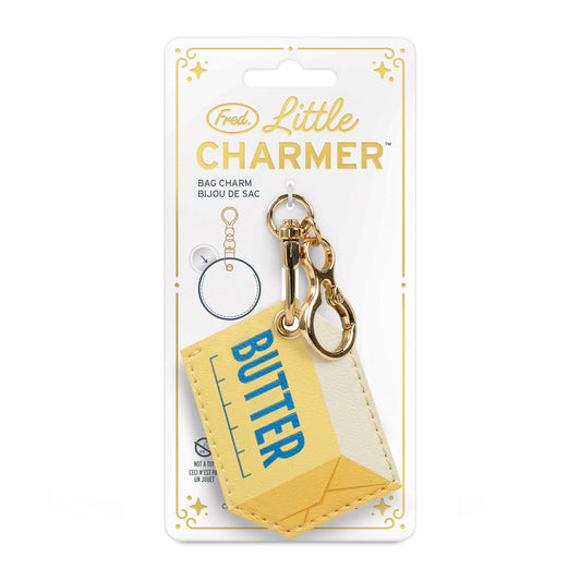 A yellow faux-leather keychain wallet shaped like a butter carton and a matching hexagonal tag, both attached to gold-tone hardware and a white key ring, on a white background.