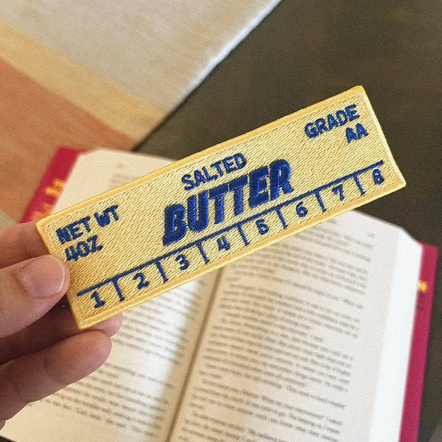 Embroidered patch shaped like a stick of butter with real-life markings: "Salted Butter. Net Wt 4oz. Grade AA"