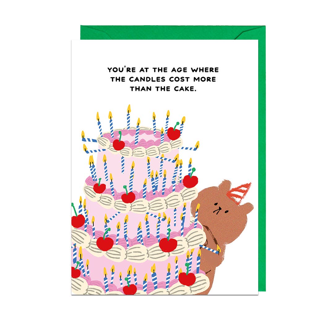 Greeting card with a 3-tier birthday cake on it and candles all over. The text up top reads "You're at the age where the candles cost more than the cake" 