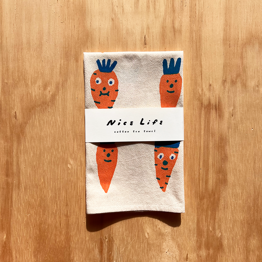 Packaged towel with cartoon carrots on a wooden surface