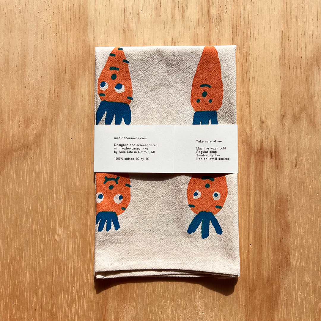 Towel with cartoon carrots design on a wooden surface