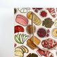 Patterned bag with illustrations of meats, bread, and condiments on a light pink background