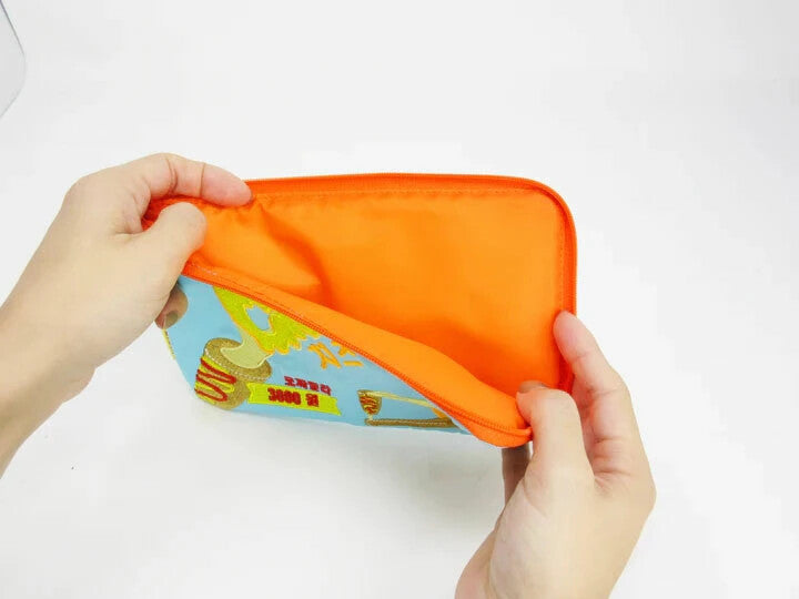 Hand opening a pouch to reveal its orange interior.