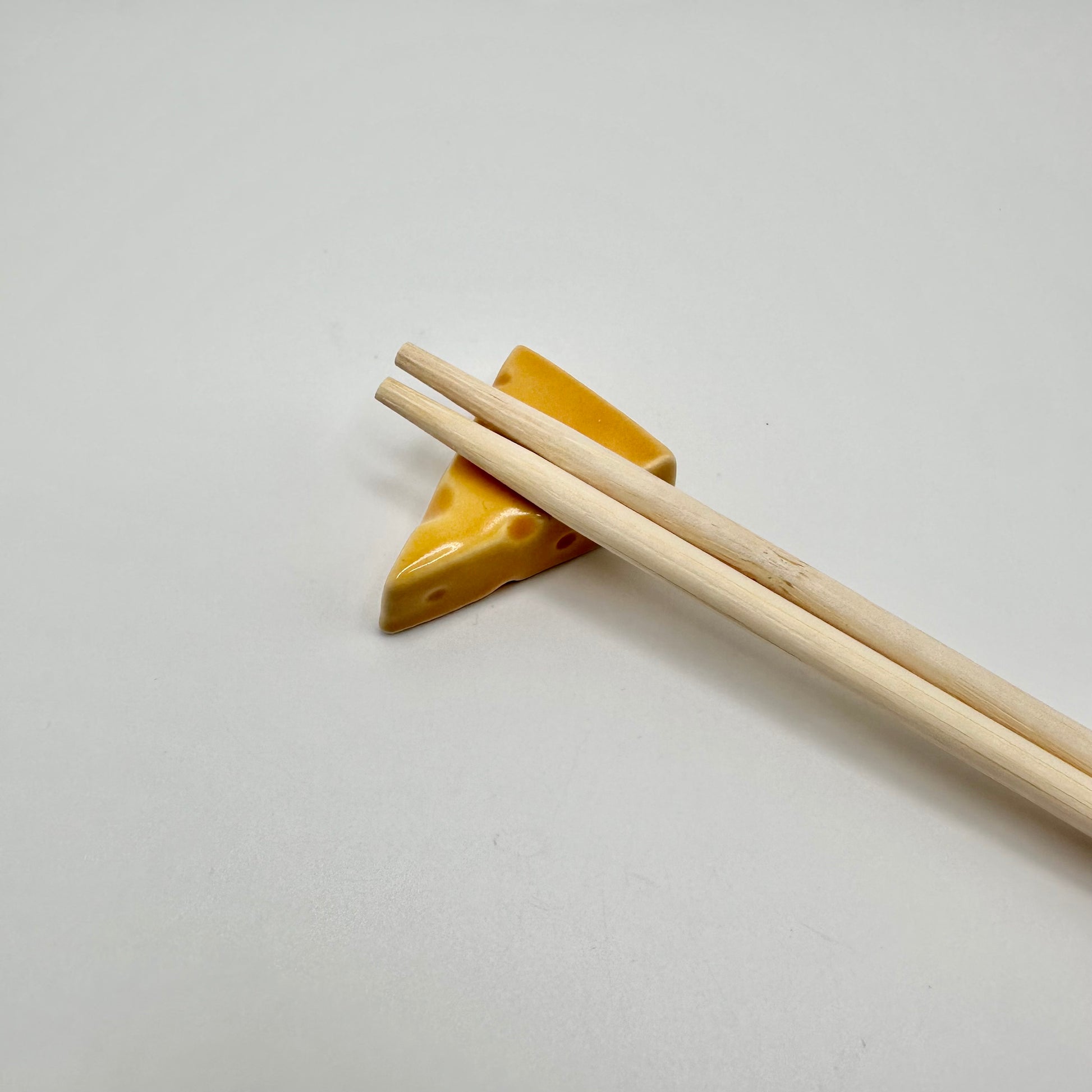 Cheese Wedge Chopstick Rest with chopsticks on them.