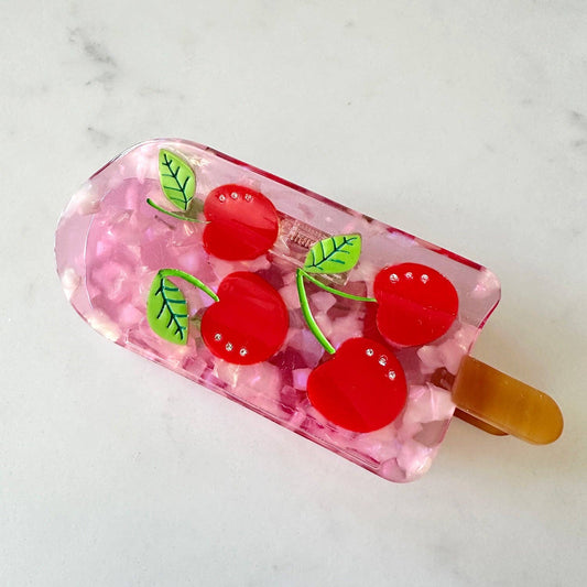 Hair claw that looks like a pink popsicle with 4 jewel studded cherries.