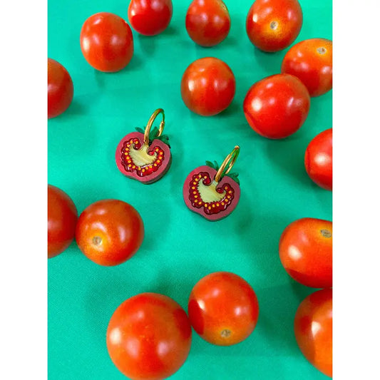 Cherry tomatoes laying on a turquoise background with real cherry tomatoes surrounding them 