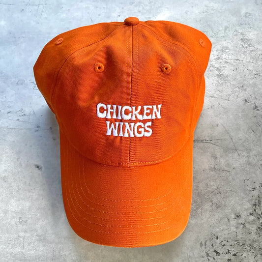 Buffalo sauce colored dad hat with text that reads: Chicken Wings