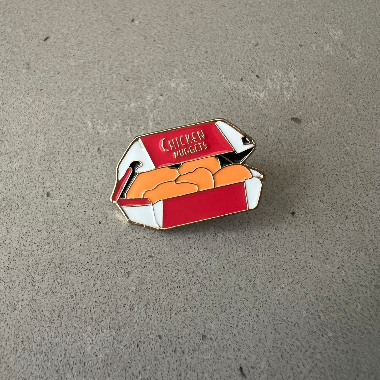 Chicken Nugget Lapel Pin. Red and white box with 5 nuggets inside. The box reads Chicken Nuggets