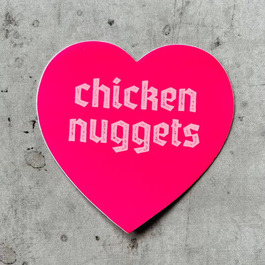 pink, heart shaped sticker with text that reads "chicken nuggets" on it 