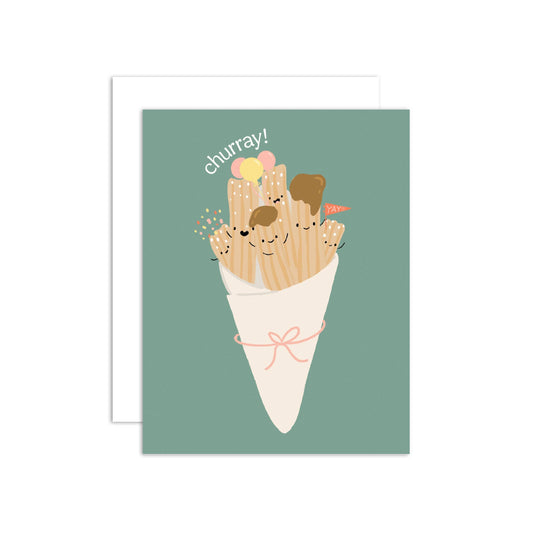 A greeting card featuring a cute illustration of a cone of churros with smiling faces, set against a muted green background. A white envelope is partially visible behind the card.