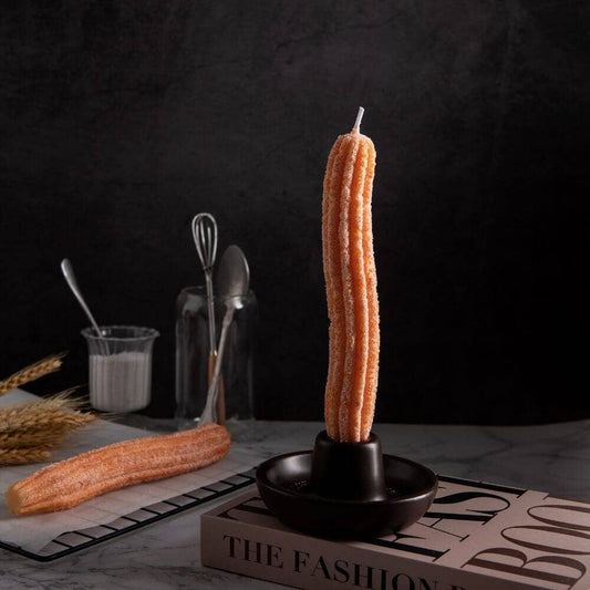 Churro tapered candles set in a backdrop with kitchen utensils.