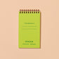 Green spiral-bound notebook on a beige background. text on page reads "If found, please return to:"