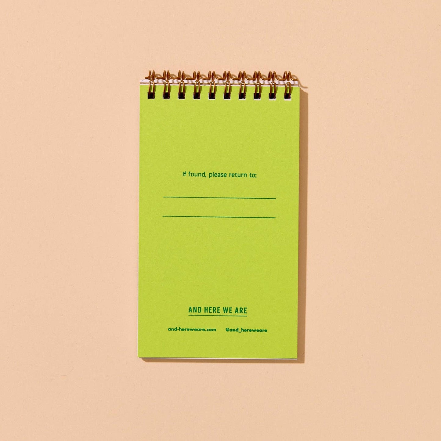 Green spiral-bound notebook on a beige background. text on page reads "If found, please return to:"
