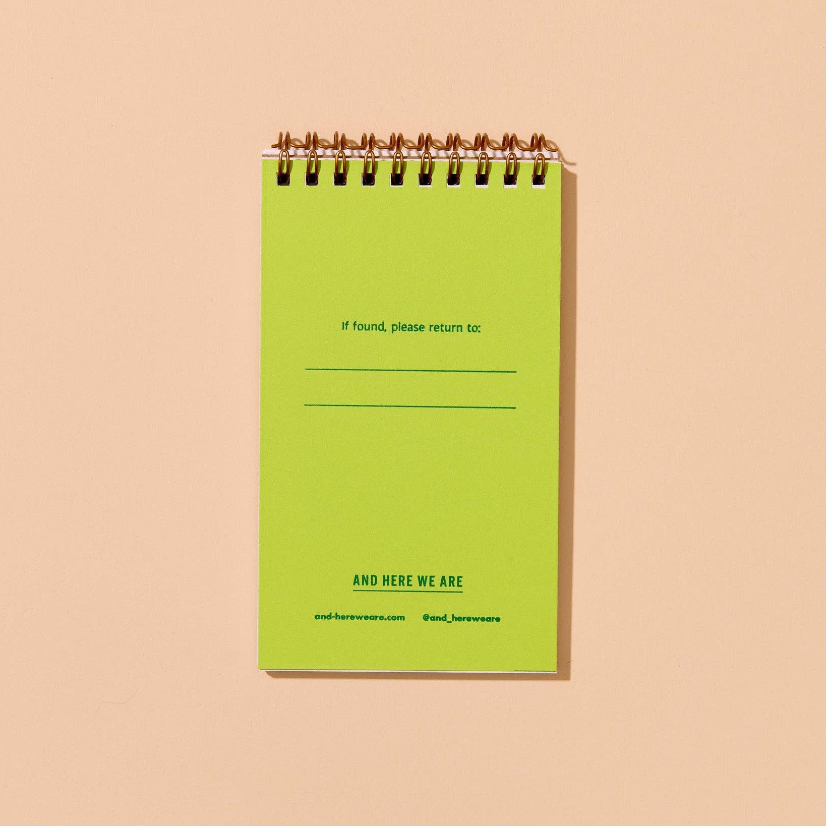 Green spiral-bound notebook on a beige background. text on page reads "If found, please return to:"