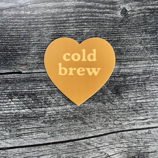 Heart-shaped 'cold brew' sticker on a wooden surface