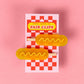 Two hairclips shaped like corndogs shown attached to red and white checkered backing board with text "Pretty Useful Co. - Fair Clips"