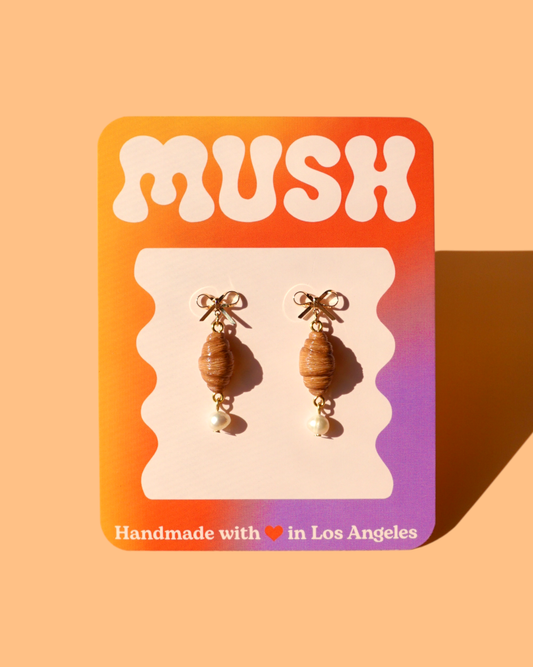 Croissant earrings on a 'MUSH' branded card with a gradient background