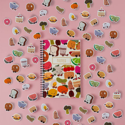 Notebook with food-themed stickers on a pink background