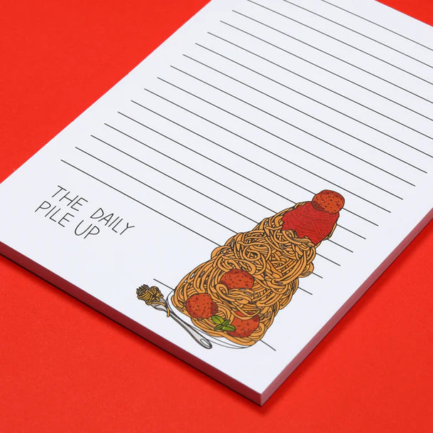 Close up photo -- Lined notepad with illustration of extra tall pile of spaghetti and meatballs with text "The Daily Pile Up" on the bottom.