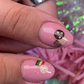 Set of decorative nail decals that look like Italian treats such rainbow cookies, pizzelles, espresso, panettone, and more. Shown on nails with pale pink nail polish.