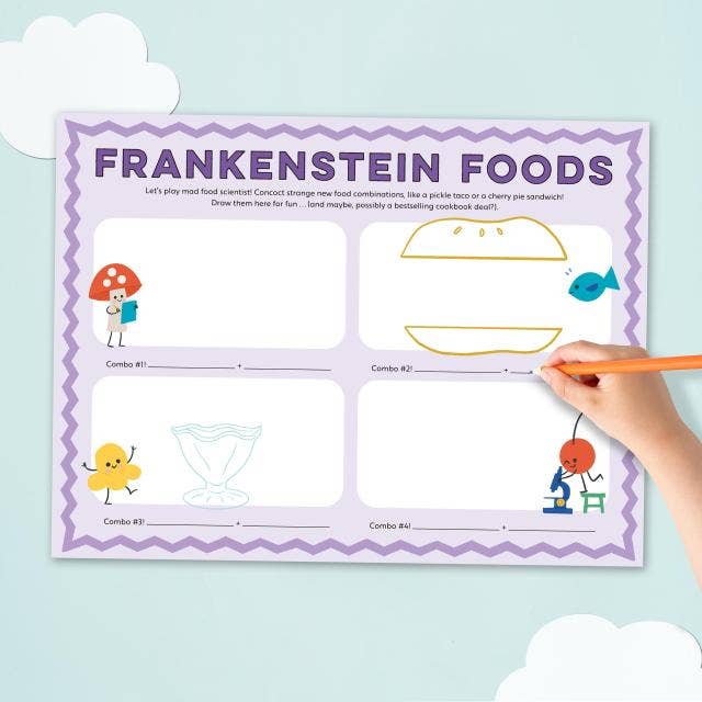 A children's activity sheet titled 'FRANKENSTEIN FOODS' with illustrated food-themed boxes and lines, shown on a light blue background with a hand holding an orange pencil pointing at the sheet.