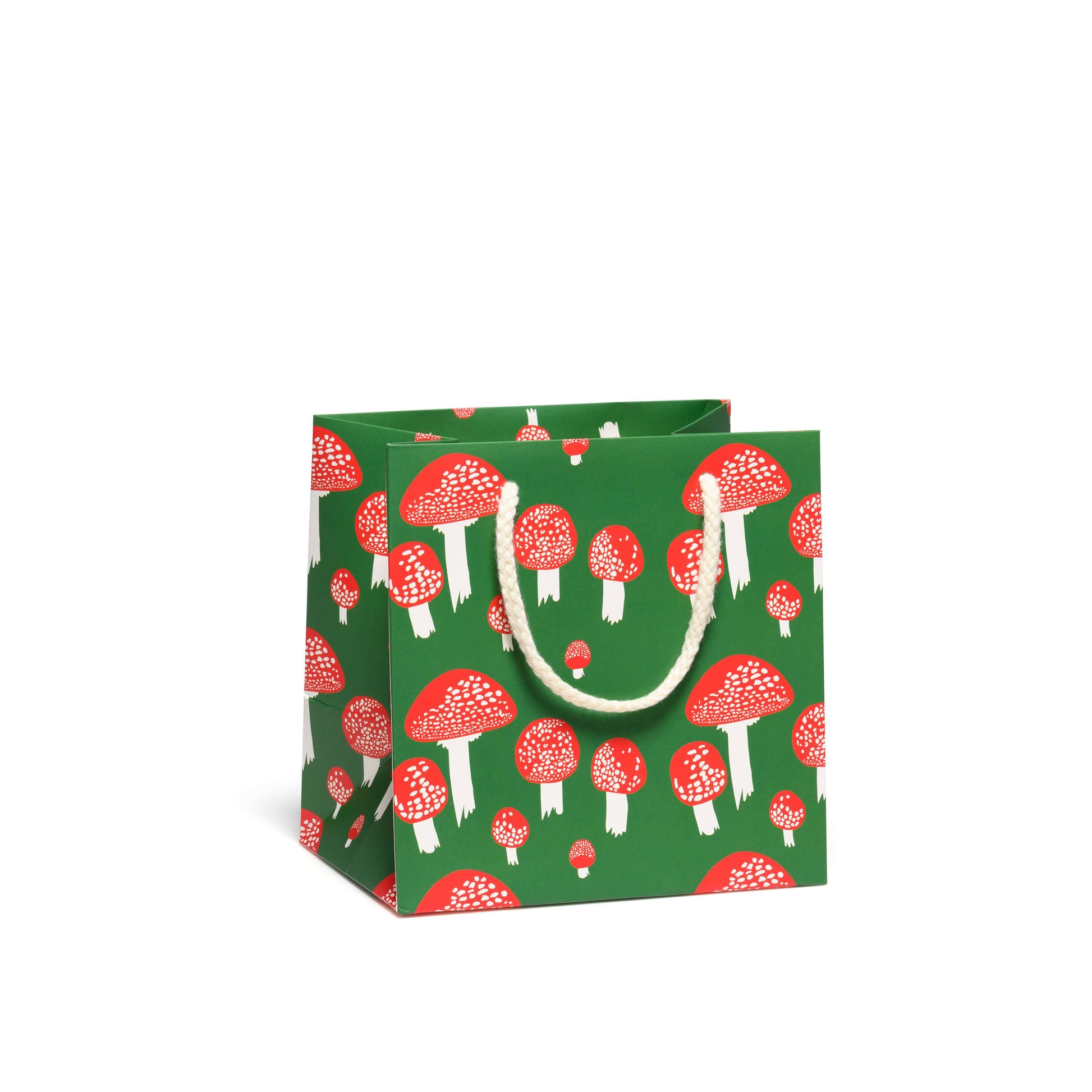 Forest green gift bag with whimsical mushroom design - red mushroom caps with white spots and white stems.