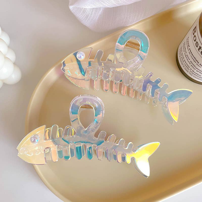 Iridescent fish-shaped object on a gold tray with a blurred background