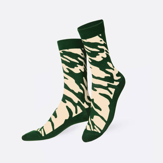 A pair of crew socks with a green and beige zebra-like stripe pattern, shown against a plain light gray background.