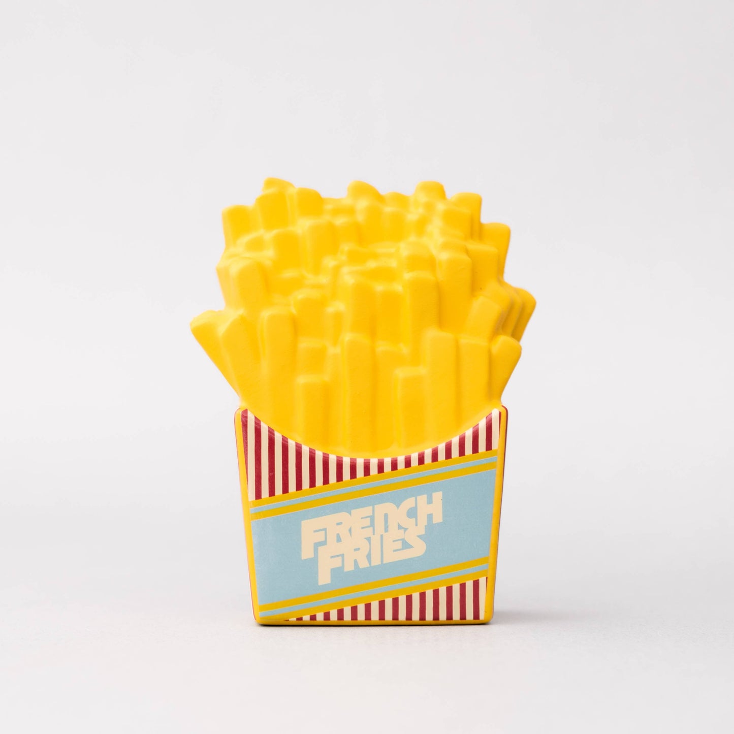 Toy French fries in a box with a striped design on a white background
