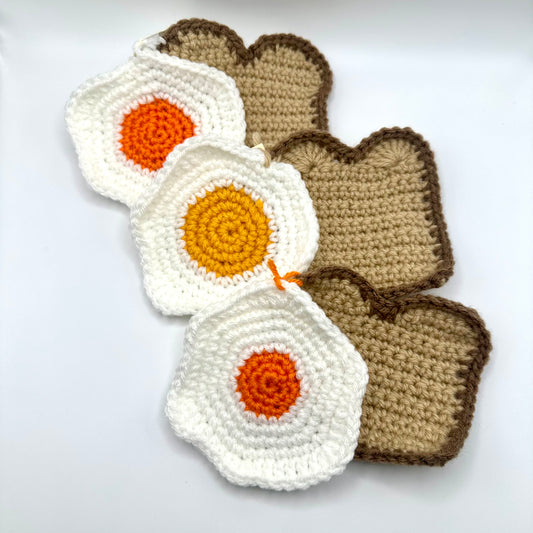 Three eggs and three toast crochet coasters. 
