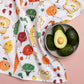 Avocados in a bowl on a colorful fabric with cartoon food characters