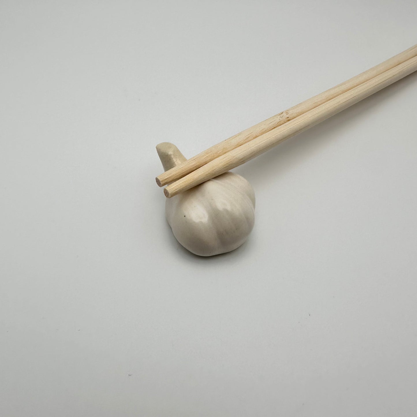 Garlic Chopstick Rest with a pair of chopsticks on it