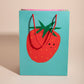gift bag with a single giant strawberry on a turquoise background