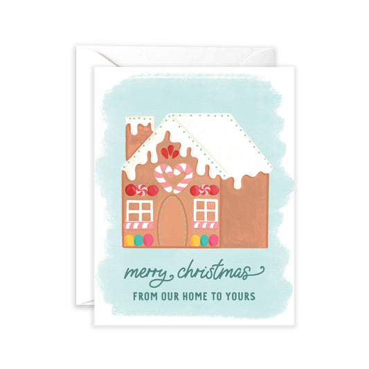 Holiday greeting card with a decorated gingerbread house on it. Text at bottom reads "Merry Christmas from our home to yours" 