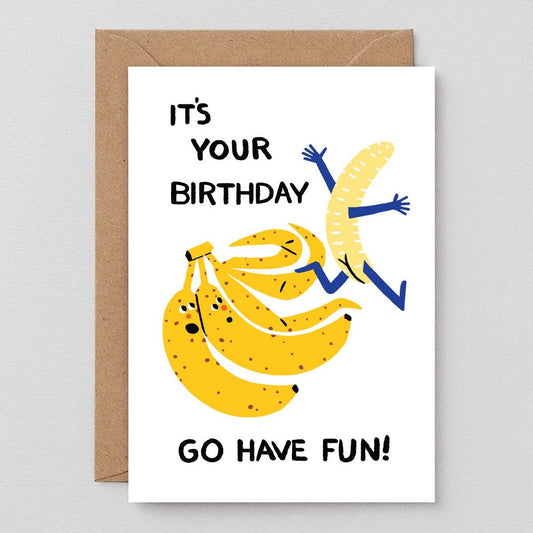 Birthday card that says "It's Your Birthday... Go Have Fun!" with an illustration of three bananas - one of the bananas has unpeeled itself and is running away from the bunch with his arms waving and little banana booty showing.