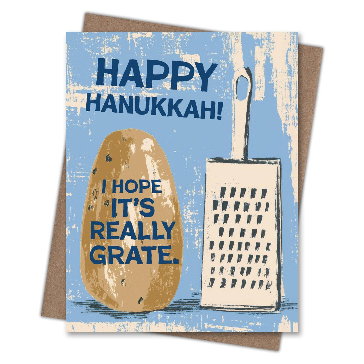 A square greeting card with a kraft envelope behind it, featuring a light blue distressed background, a brown potato illustration, and a cream-colored grater. The text reads 'HAPPY HANUKKAH!' at the top and 'I HOPE IT'S REALLY GRATE.