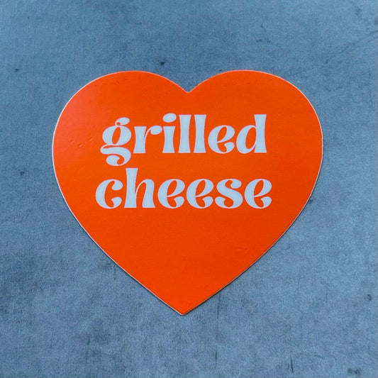 Orange heart shaped sticker with text that reads: Grilled Cheese