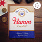 Greeting card with 'Happy Father's Day' and 'Hamm it up dad!' text on a wooden surface.