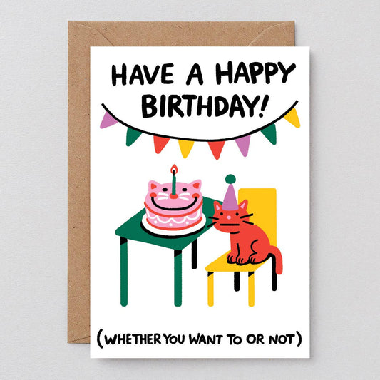 birthday card with a reluctant cat wearing a party hat and a cat shaped cake on a table
