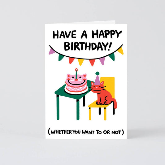 birthday card with image of cat wearing a party hat and a cat shaped cake on the table
