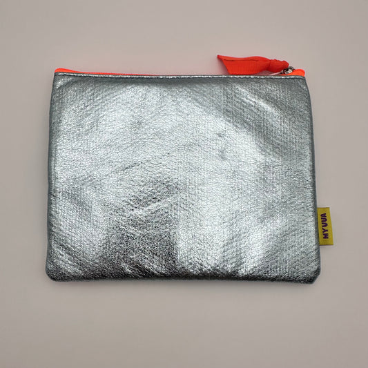 Back side of pouch showing a blank silver material and a tag that says MUUUA