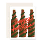 3 beer bottles wrapped with pine garland. Cursive red font that reads: Hoppy Holidays.